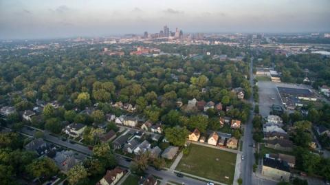 An arial view of Indianapolis with neighborhoods in the foreground and the downtown skyline in the background.