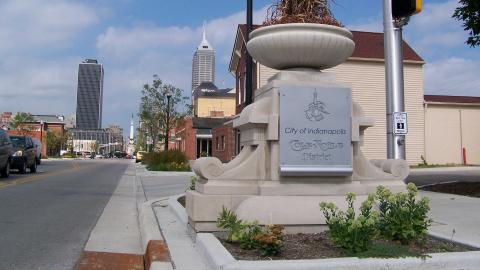 A gateway sign designating Cole Noble, looking west towards the Indianapolis skyline