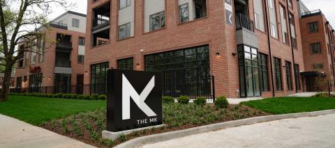 An apartment building with a sign in front showing a logo consisting of MK, for Meridian Kessler.