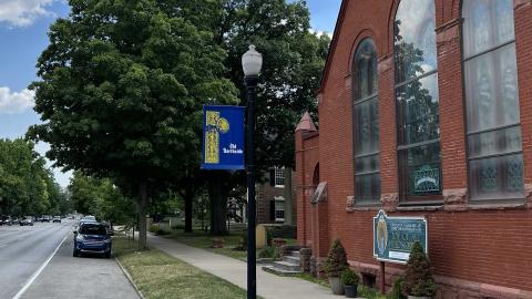 A lightpole banner highlighting the Old Northside outside an old red brick church.
